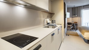 A compact kitchenette with a built-in stove, a sink, and a coffee maker. - Double apartment (Banyoles)