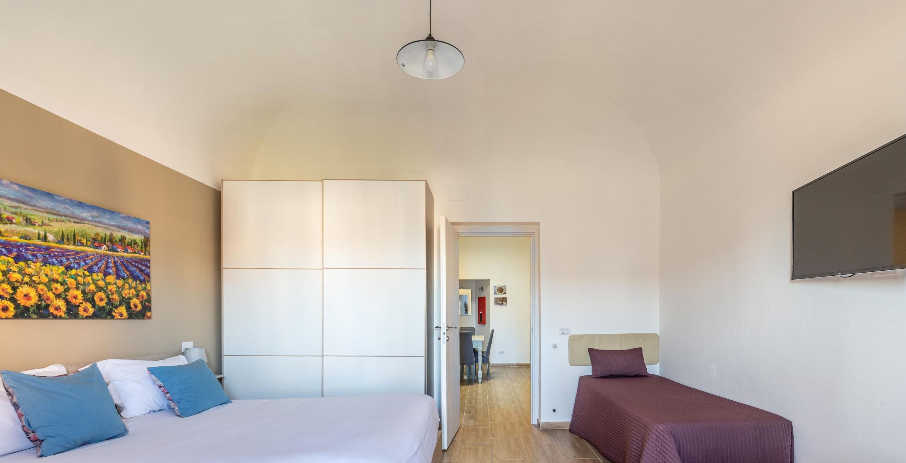 Een slaapkamer met een bed, een bureau en een stoel.