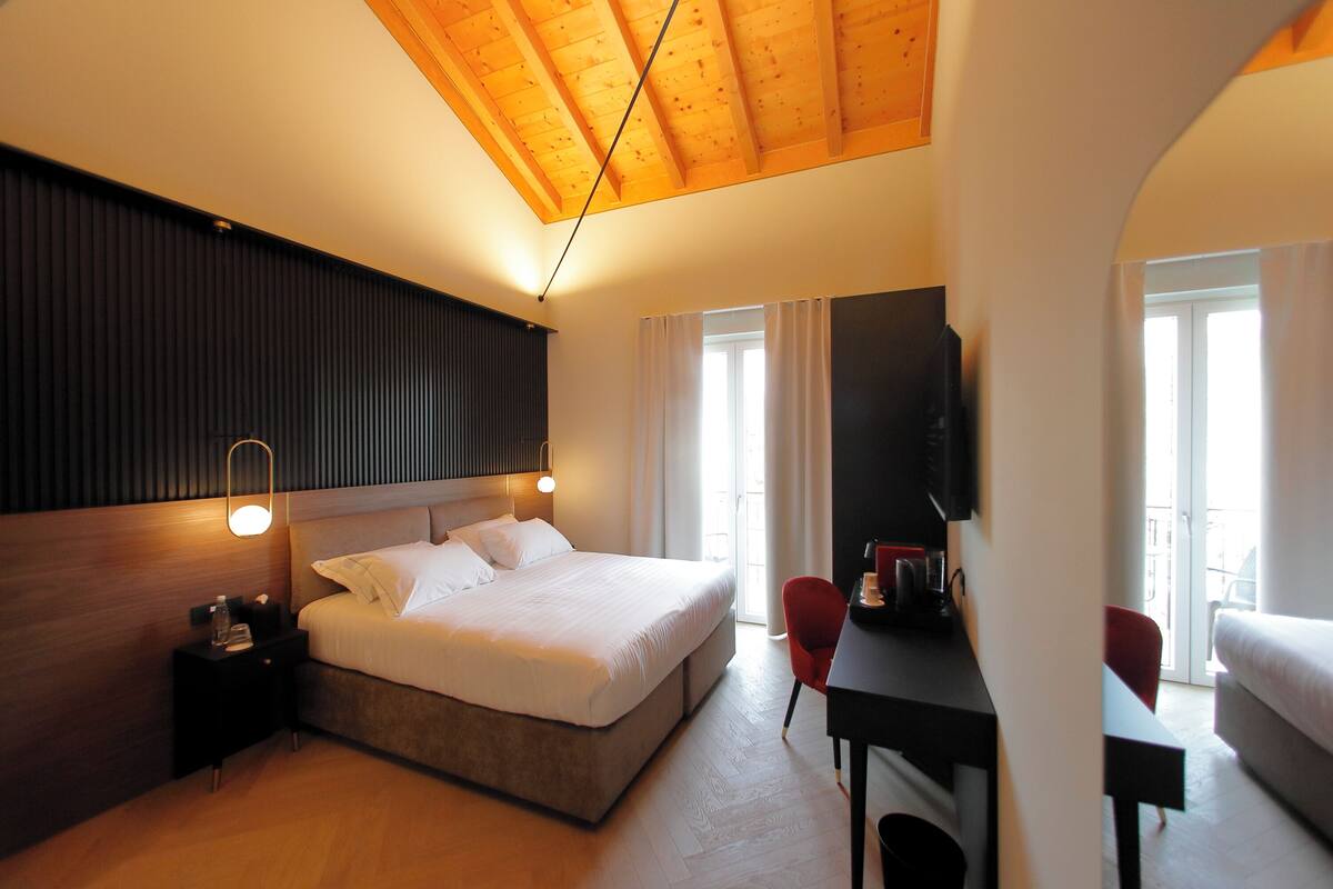 Une chambre d’hôtel moderne, dotée d’un grand lit, d’un bureau et d’une télévision.