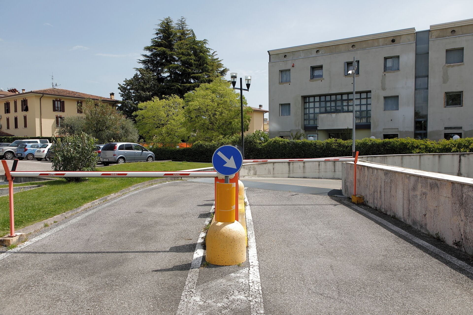 Une route avec un panneau de signalisation bleu indiquant la direction et un potelet jaune.