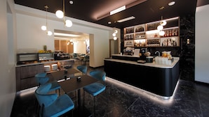 Eine moderne Hotelhalle mit Bar, Sitzgelegenheiten und einem Buffet.