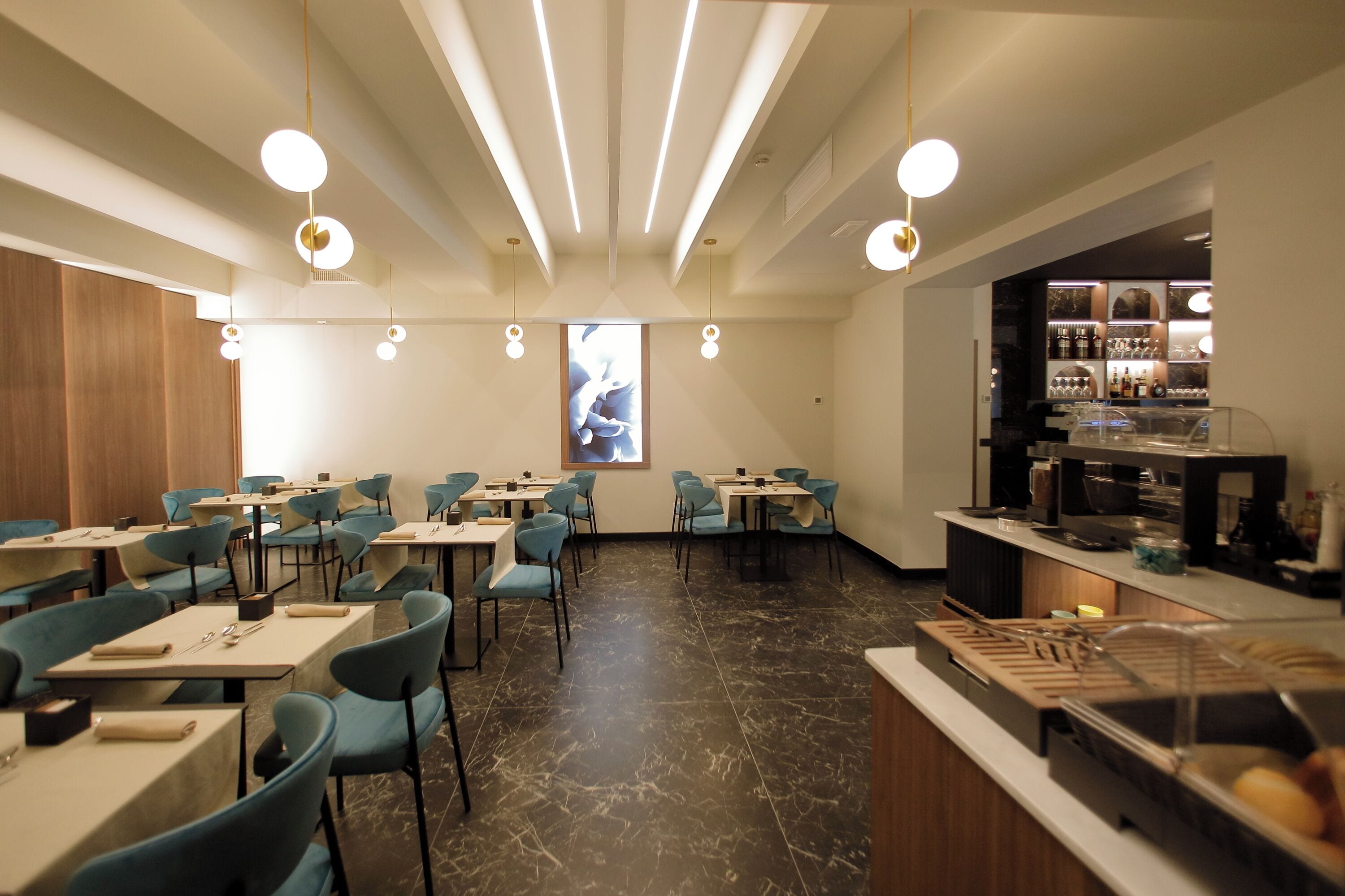Un ristorante moderno con una sala da pranzo centrale, una zona bar con un bancone e scaffali, e un'ampia vetrata con vista.