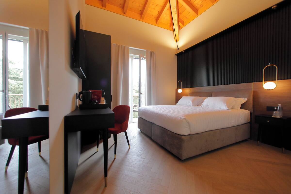 Une chambre à coucher moderne avec un lit, un bureau et un téléviseur.