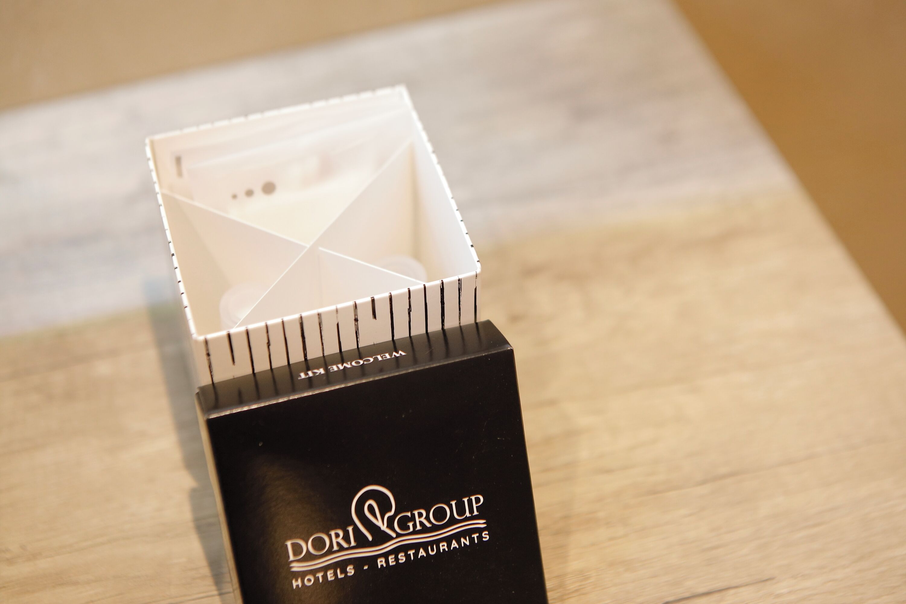A black box with the text "DORI GROUP HOTELS - RESTAURANTS" and a white interior box with a grid pattern.