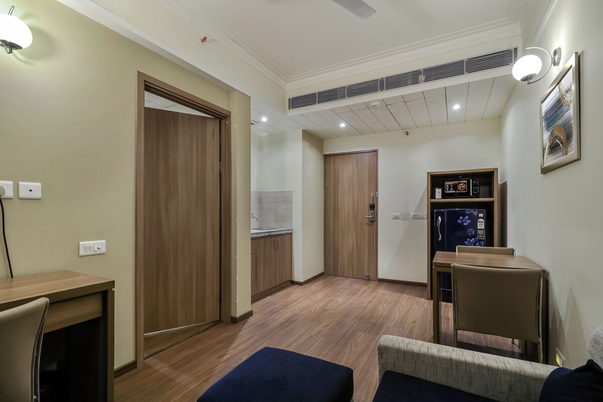 A compact living space with a kitchenette, a dining area, and a seating area.