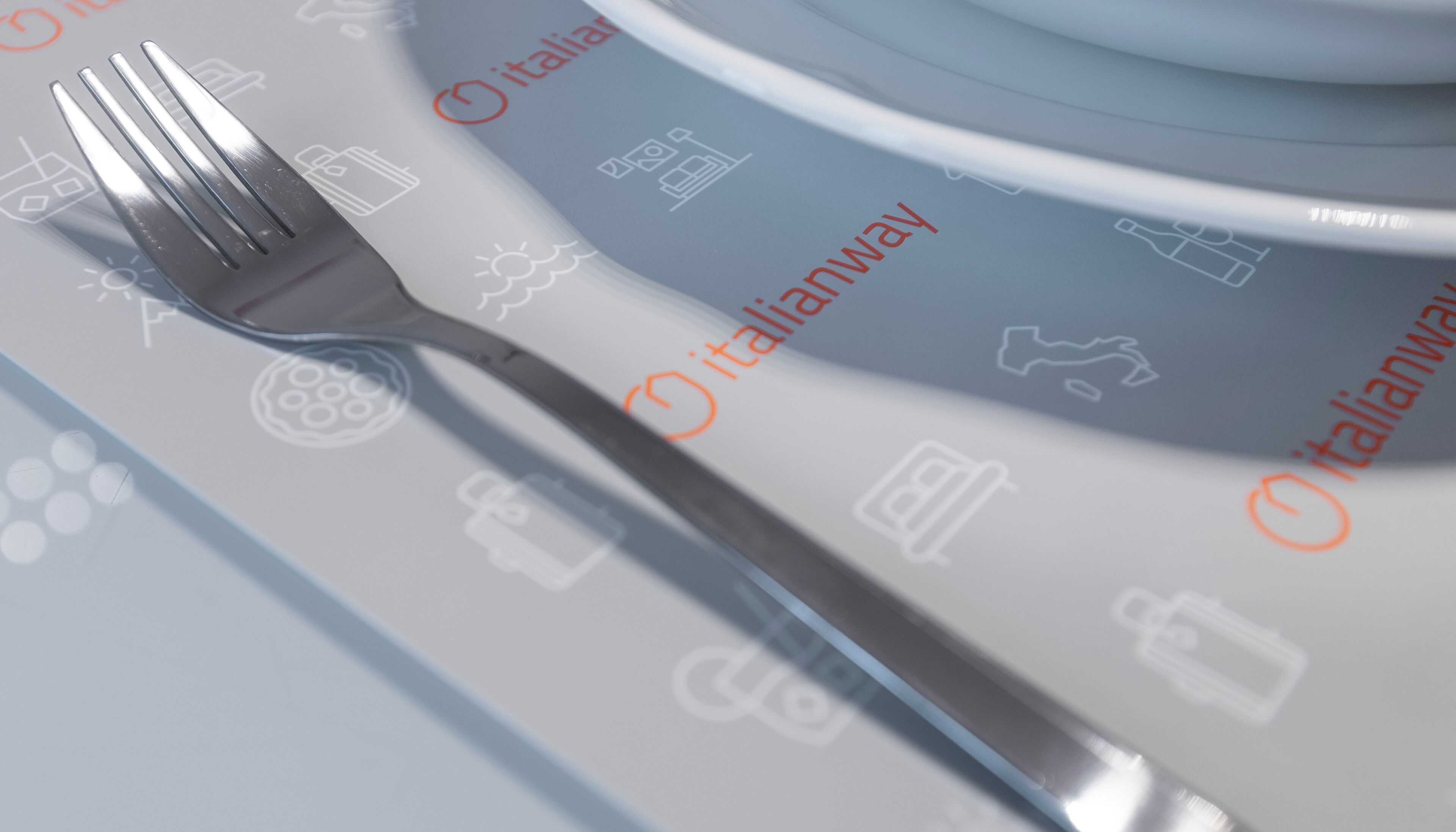 Une fourchette sur une table, avec des icônes et le mot « italianway » visible.