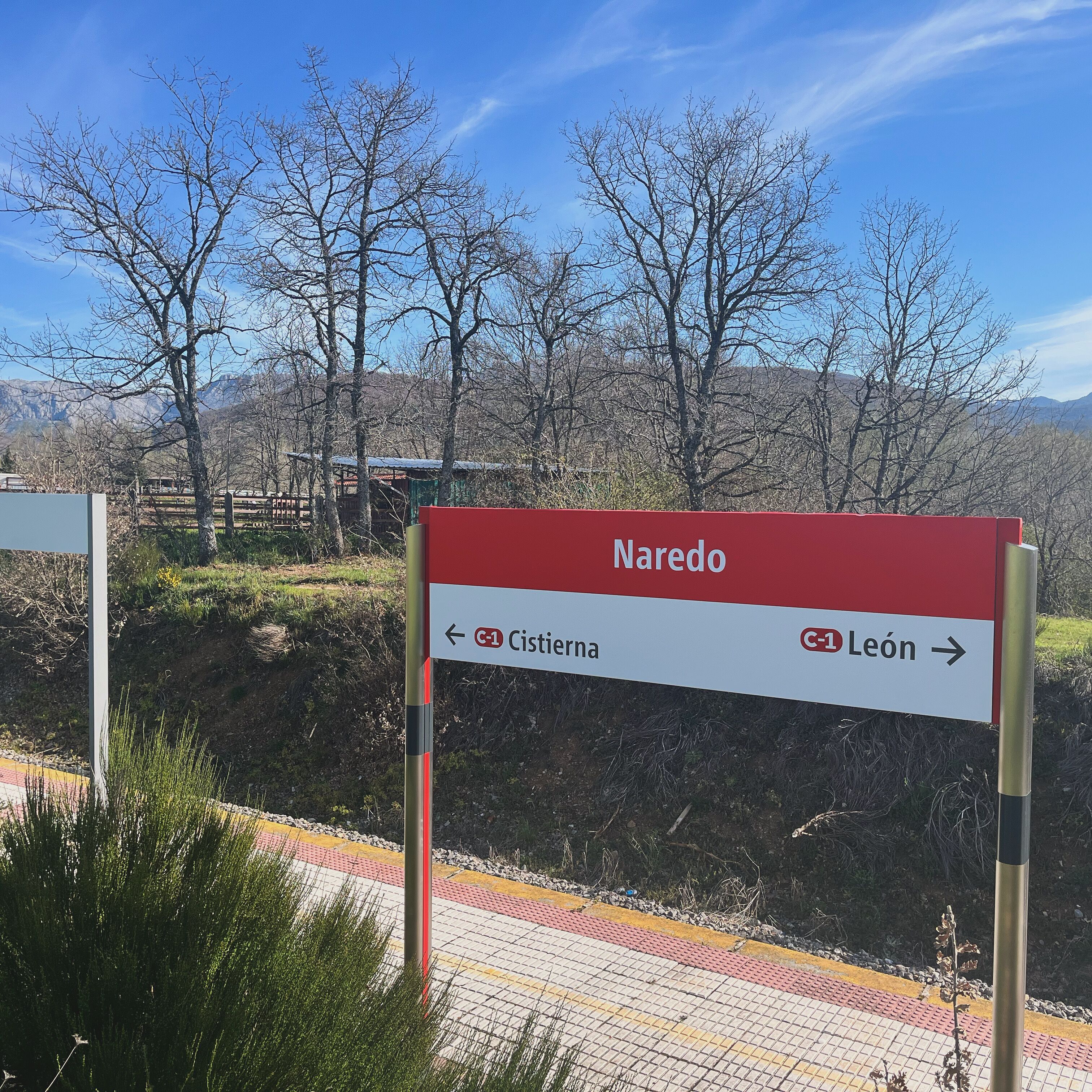 Una señal direccional con 'Naredo' en la parte superior y flechas indicando a la izquierda 'C-1 Cistierna' y a la derecha 'C-1 León'.