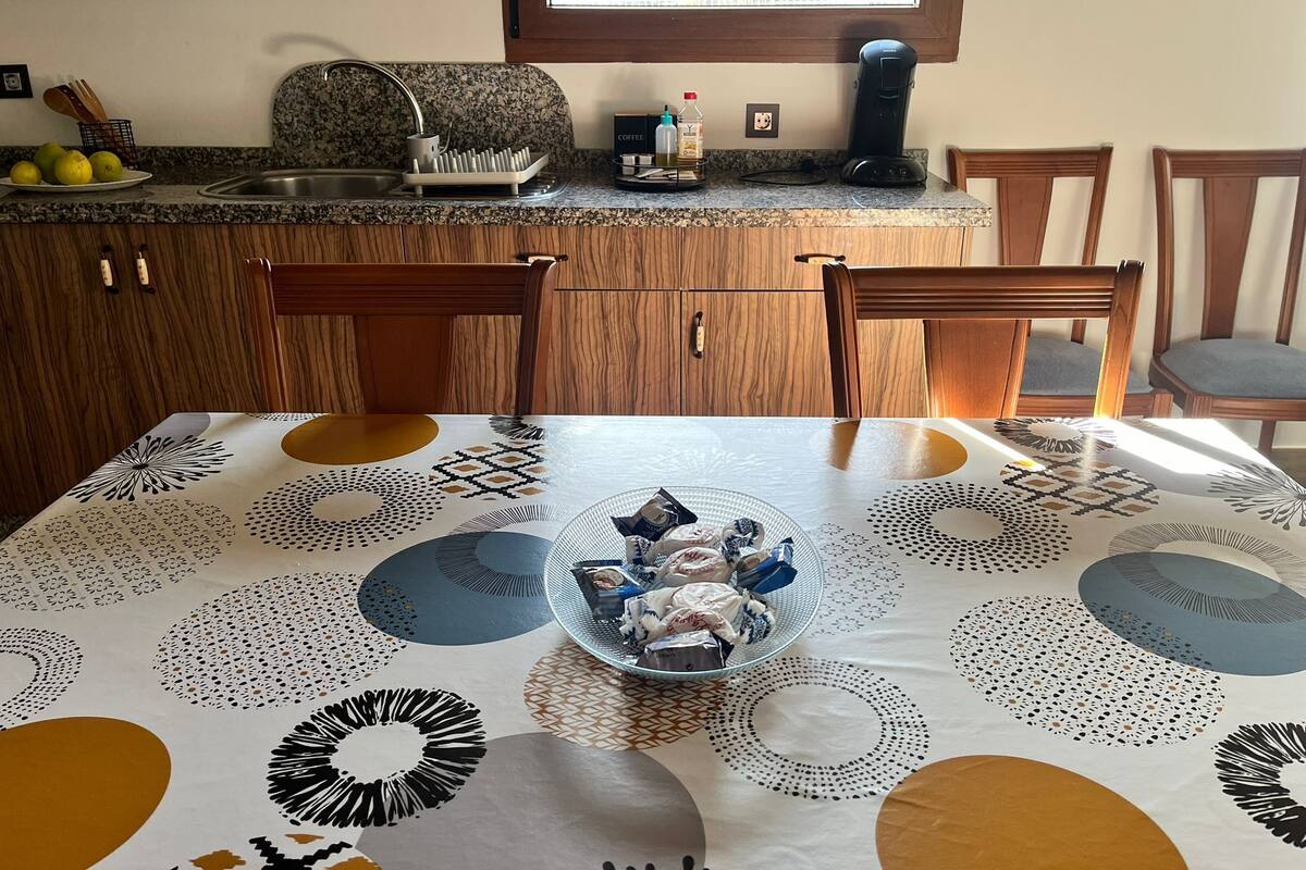 Une cuisine dotée de plans de travail en granit, de meubles en bois, d’une machine à café et d’une fenêtre offrant une belle vue.