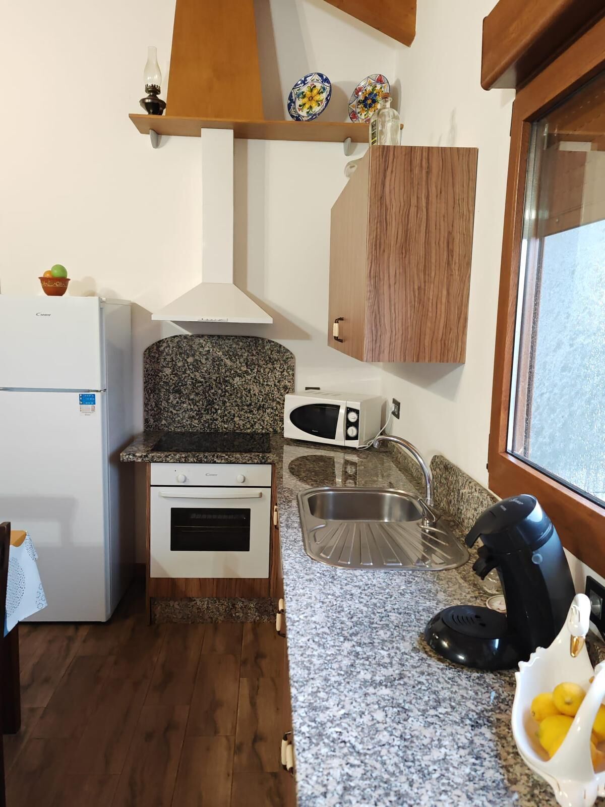 A compact kitchen with a refrigerator, oven, microwave, and sink.