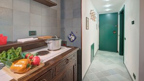 A kitchen with a wooden countertop, a stove, and a variety of fresh vegetables. - Fiori di Miele few Step From Skiing (Bardonecchia)