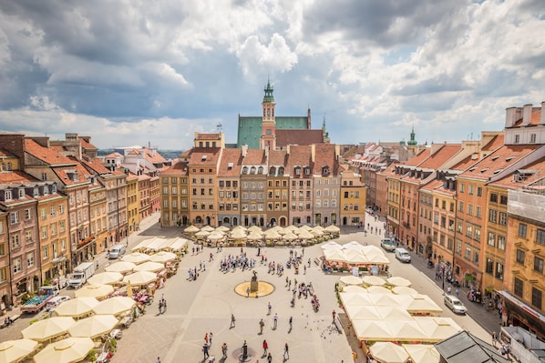 A spacious public square with numerous outdoor seating areas and a central fountain. - Rozbrat Studio (Warsaw)