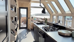 Una cocina moderna con tragaluces, una isla central y vistas al exterior.
