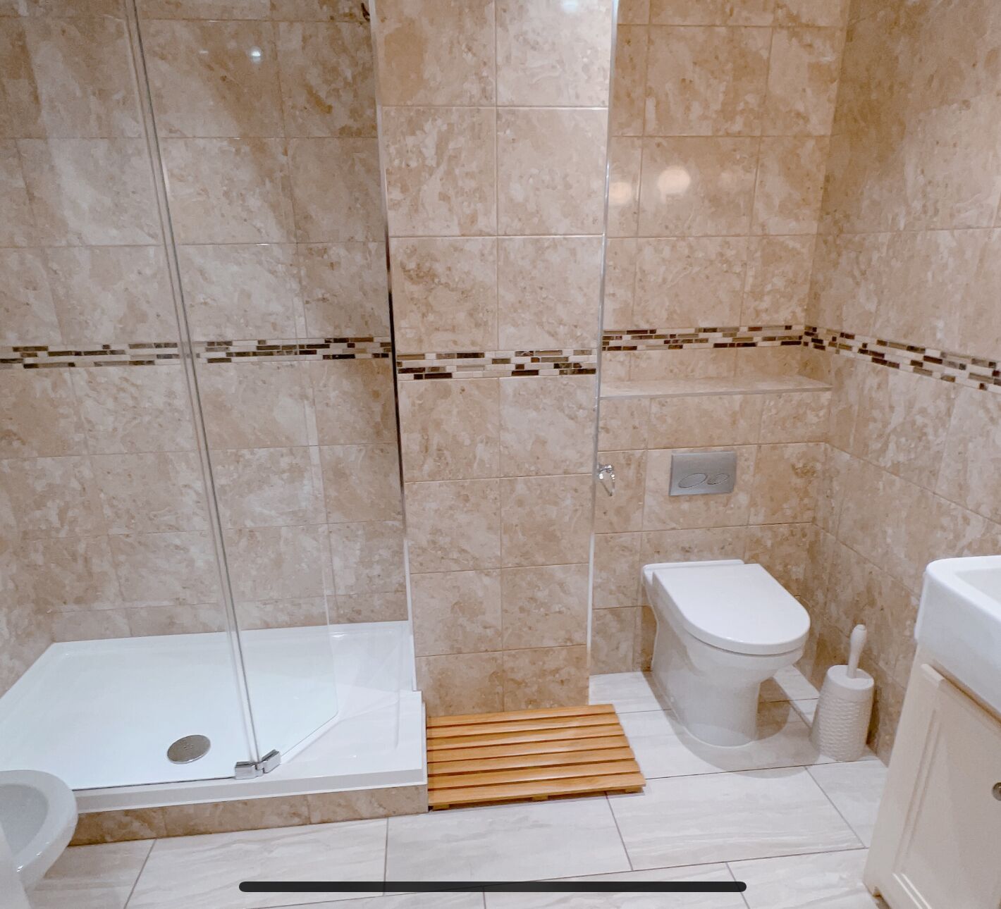 A bathroom with a shower, toilet, and sink.