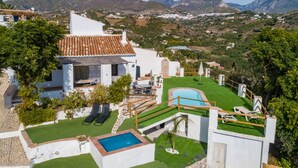 A villa with a swimming pool, a patio, and a view of the surrounding hills. - Cortijo Horizonte Solset (Frigiliana)