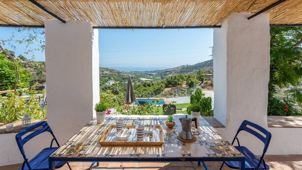 A terrace with a table set for tea, overlooking a pool and scenic landscape. - Cortijo Horizonte Solset (Frigiliana)