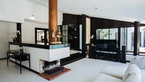 A modern living room with a fireplace, a large black TV, and a white sofa. - FOZ DO NEIVA 16 - Luxury stay in Foz do Neiva, Esposende, Portugal (Guilheta)