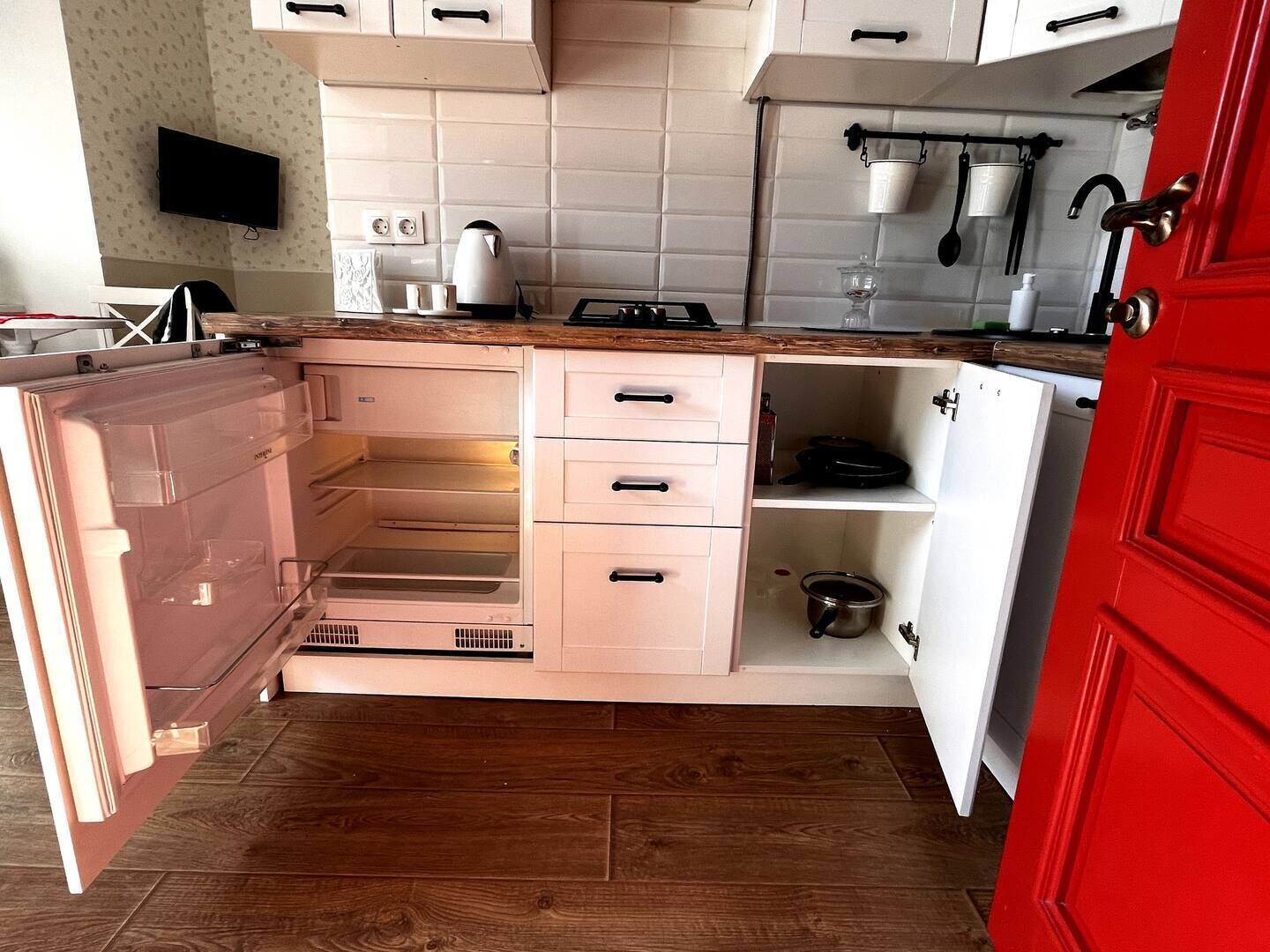 Une cuisine compacte équipée d’un réfrigérateur intégré, d’un four à micro-ondes et d’une cuisinière.