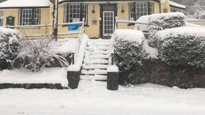 A two-story building with a snow-covered roof and a front entrance. - The Railway Inn (Malvern)