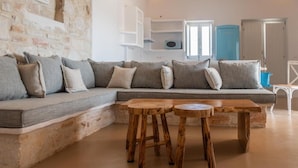 Ein modernes Wohnzimmer mit einem Ecksofa, einem Holztisch und integrierten Regalen.
