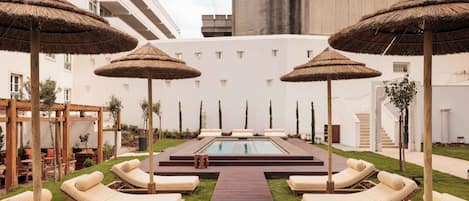 Una piscina al aire libre de temporada, sombrillas