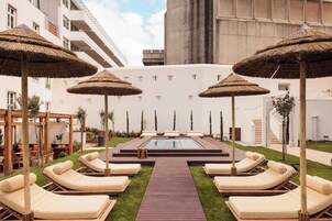 Una piscina al aire libre de temporada, sombrillas