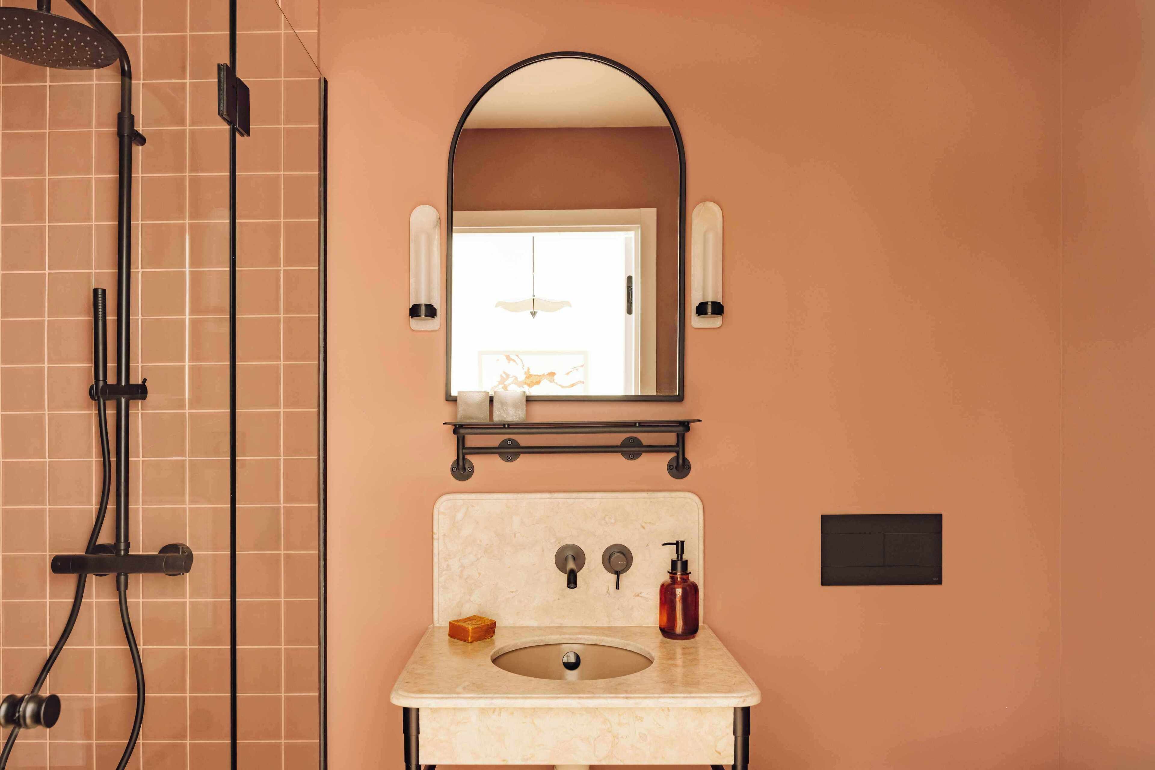 Un baño con ducha, lavamanos y espejo.