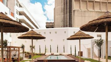 Una piscina al aire libre de temporada, sombrillas