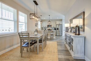 Enjoy meals in the kitchen with stainless steel appliances and a central island, surrounded by a dining area with a wooden table and chairs.
