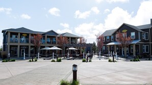 A hotel with multiple dining areas, outdoor seating, and a spacious courtyard.