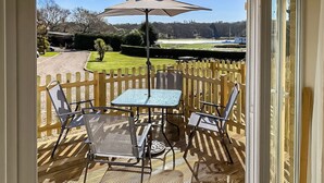 A balcony with a table and chairs, a wooden fence, and a view of a golf course. - Stunning property and location with fabulous views overlooking Wootton Creek. (Wootton Bridge)