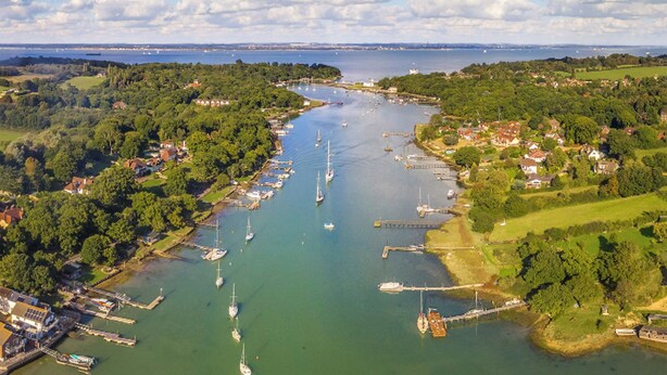 An aerial view of a coastal town with a marina, boats, and surrounding greenery. - Stunning property and location with fabulous views overlooking Wootton Creek. (Wootton Bridge)