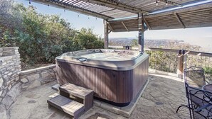 A hot tub under a pergola with a view of the city. - On Top Of SpiderMountain-2Bed/2Bath-HotTub-Gameroom. (Burnet)