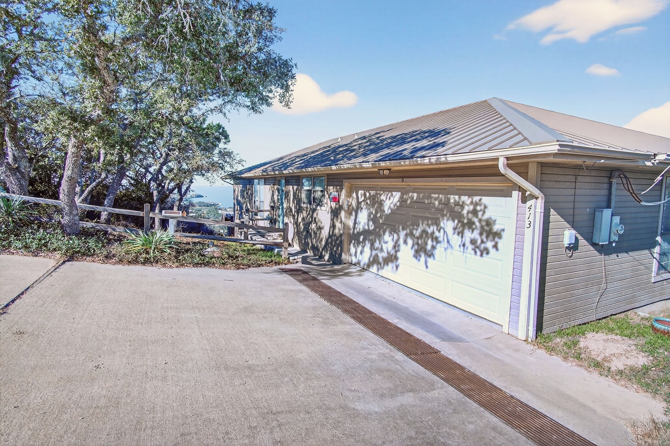 Une maison de plain-pied avec un garage, une véranda et un toit équipé de panneaux solaires.
