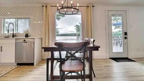 Une cuisine moderne avec un coin repas, un lustre et une vue sur l’extérieur.