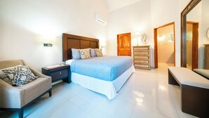 A bedroom with a bed, nightstand, chair, dresser, and a mirror. - Villa Perla 15 At Playacar phase ll NAS (Playa del Carmen)