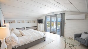 Et moderne soveværelse med seng, natbord, fjernsyn og et glasbord.
