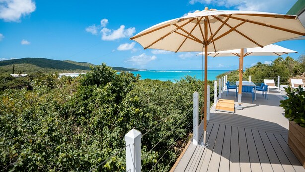 A deck with outdoor seating and a large umbrella, overlooking a beach and ocean. - Sea View Villa @ Flamenco Beach, Culebra, Puerto Rico (Flamenco)