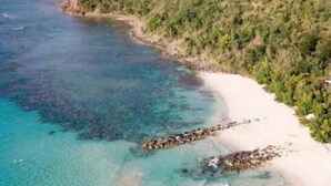 An aerial view of a beach with clear turquoise waters, a sandy shore, and a forested hillside. - Sea View Villa @ Flamenco Beach, Culebra, Puerto Rico (Flamenco)