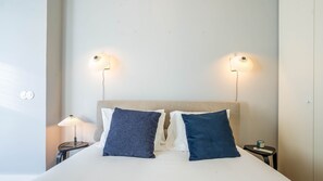 Une chambre d’hôtel avec un lit, deux lampes de chevet et une table de chevet avec une lampe.