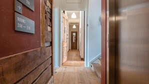 A hallway with wooden flooring and a sign indicating rooms 206-210.