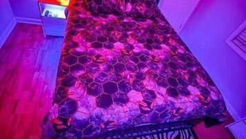 A bedroom with a bed, a nightstand, and a zebra-patterned rug.