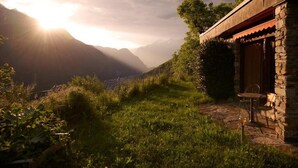 A stone building with a rustic exterior and a patio area. - Secluded Mountain Gem: 1800m² Private Garden, Outdoor Kitchen & Stunning Views (Faido)