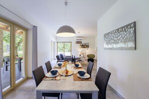 Enjoy meals in this stylish dining area with a large window and a beautiful abstract painting above the table.