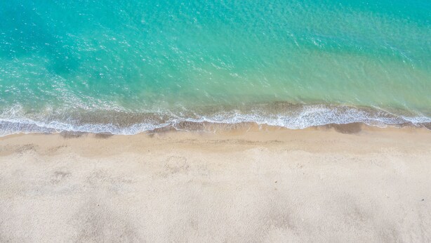 A beach with clear turquoise water and a sandy shore. - Villa by the sea with garden (Piana Calzata)