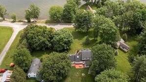An aerial view of a residential area with houses, trees, and a body of water.