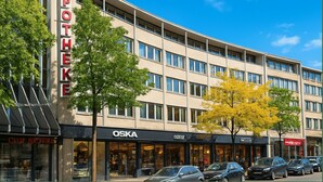 A multi-story building with a sign reading 'APOTHEKE' on the left. - Washington Apartment (Hannover)