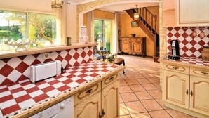 A kitchen with a checkered tile floor, wooden cabinets, and a built-in oven.