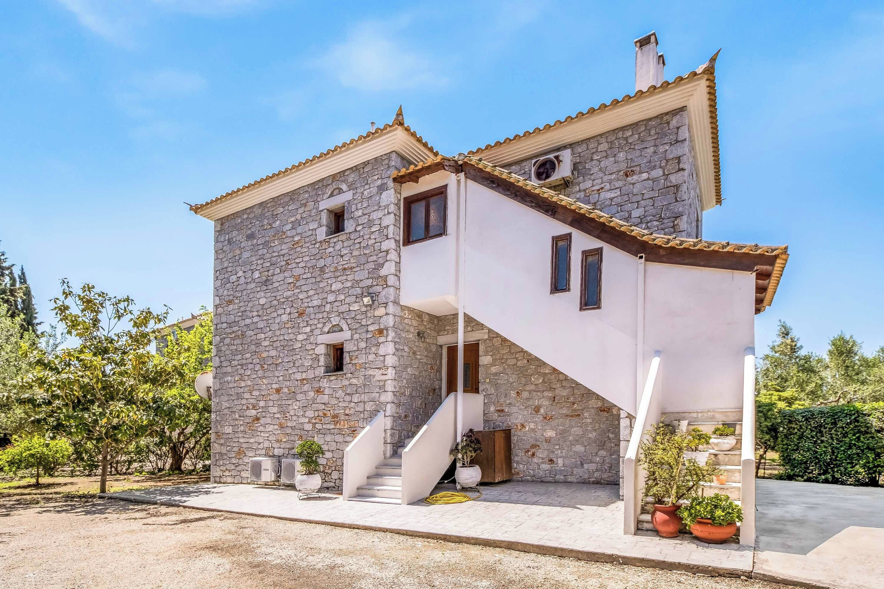 Un edificio in pietra di due piani con facciata bianca e tetto in tegole.