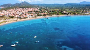 A coastal town with clear blue waters, boats, and a pier. - Villa Petra - Two Bedroom Villa, Sleeps 4 (Pilos Nestor)