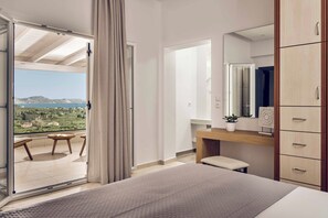Une chambre avec un balcon, un lit, un bureau et une armoire.
